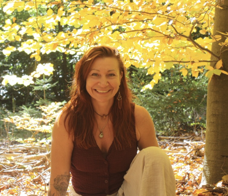 Kinga Klos sitzt l&auml;chelnd im Wald